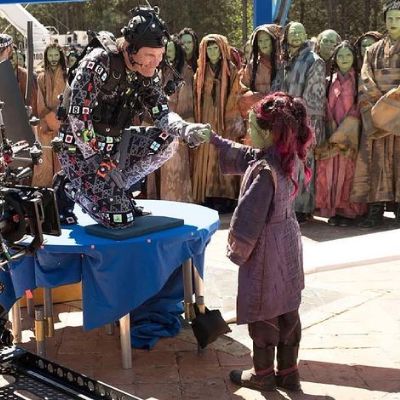 Josh Brolin is holding Ariana Greenblatt's hand as he is speaking to her while people are looking on.